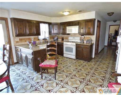 12 Sherwood Road Edison, NJ 08820 - Photo 2 of 23 a kitchen with a sink stove and cabinets