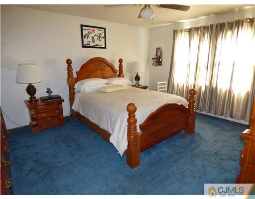 12 Sherwood Road Edison, NJ 08820 - Photo 17 of 23 a bed sitting in a bedroom next to a window