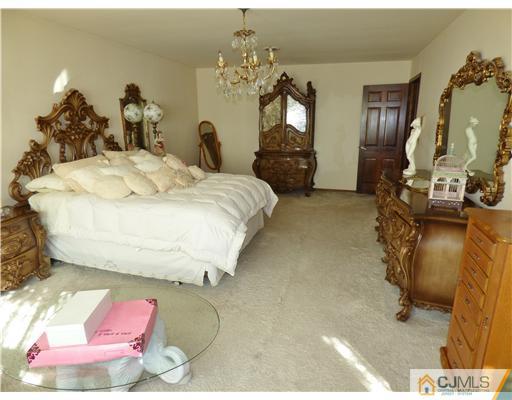 12 Sherwood Road Edison, NJ 08820 - Photo 6 of 23 a bedroom with a bed and dresser with mirror