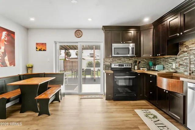 a kitchen with stainless steel appliances granite countertop a stove a sink and a microwave