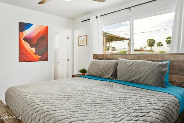 a bedroom with a large bed and a window with the outer view