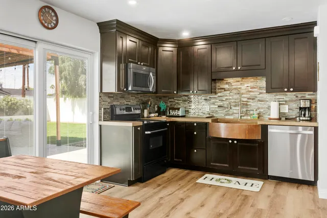 a kitchen with stainless steel appliances granite countertop a stove a refrigerator and a sink