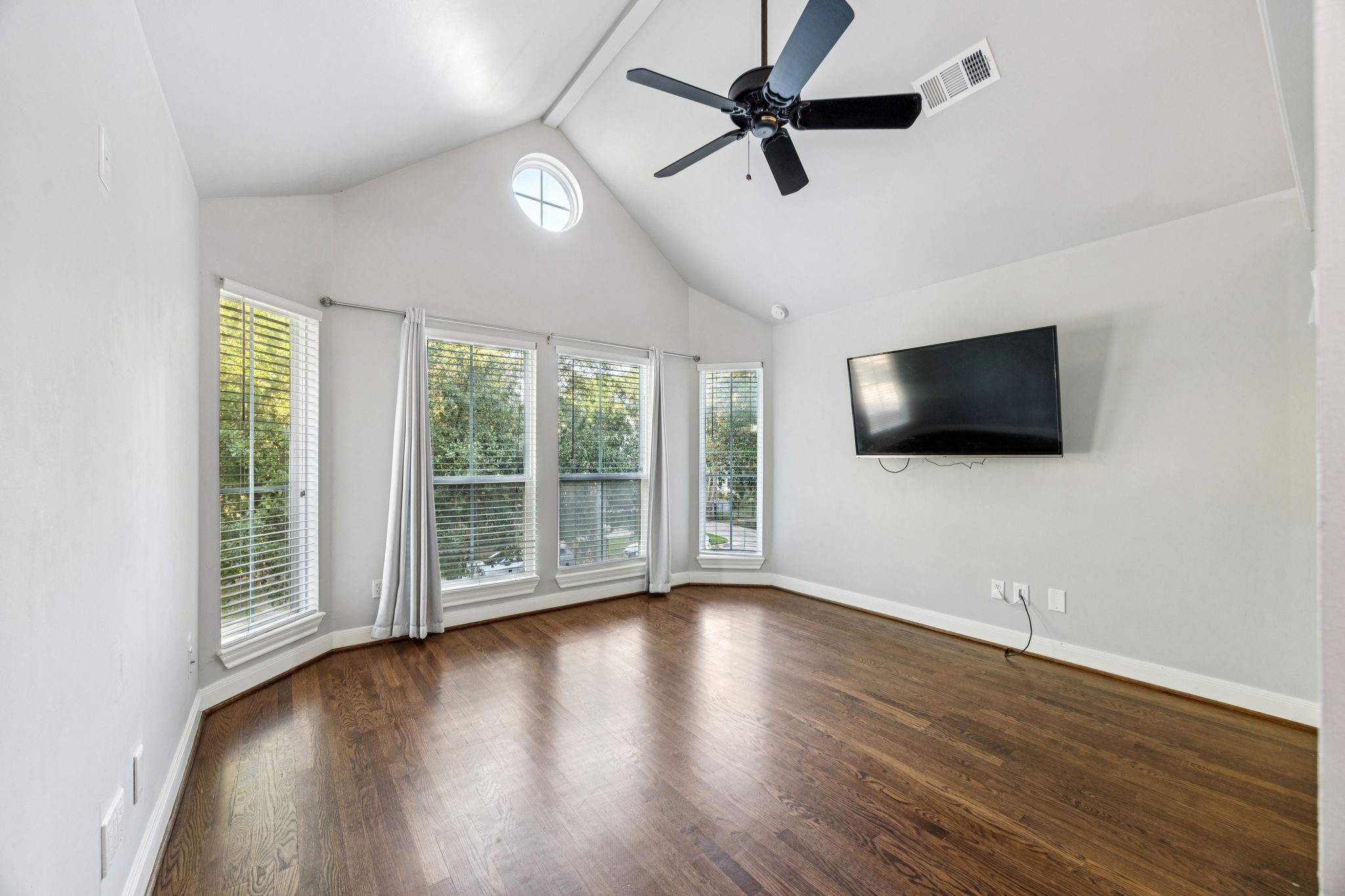 220 East 8th Street Houston, TX 77007 - Photo 17 of 35 a view of a livingroom with wooden floor a ceiling fan and windows
