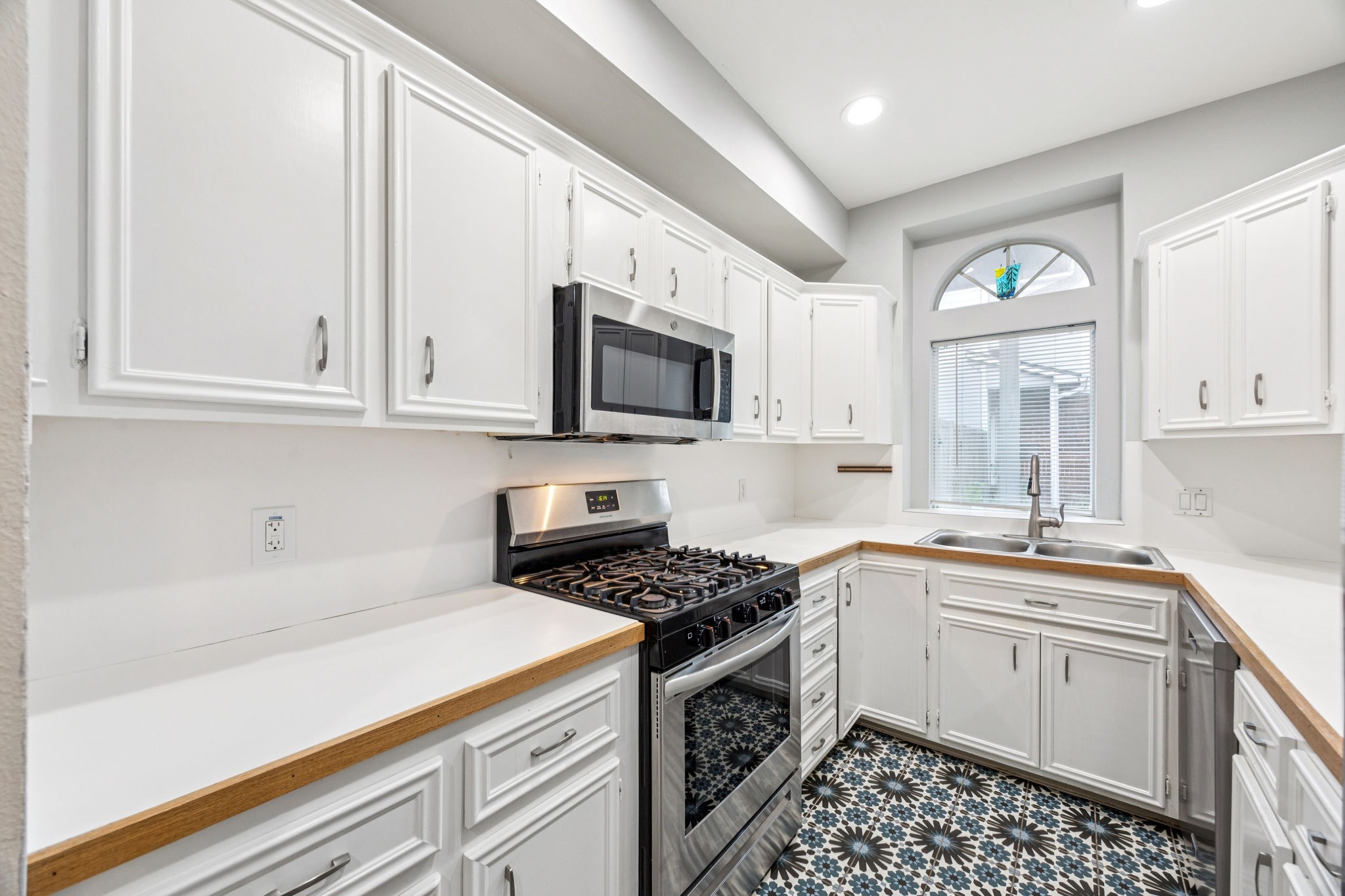 220 East 8th Street Houston, TX 77007 - Photo 10 of 35 a kitchen with granite countertop a sink a stove a microwave and cabinets
