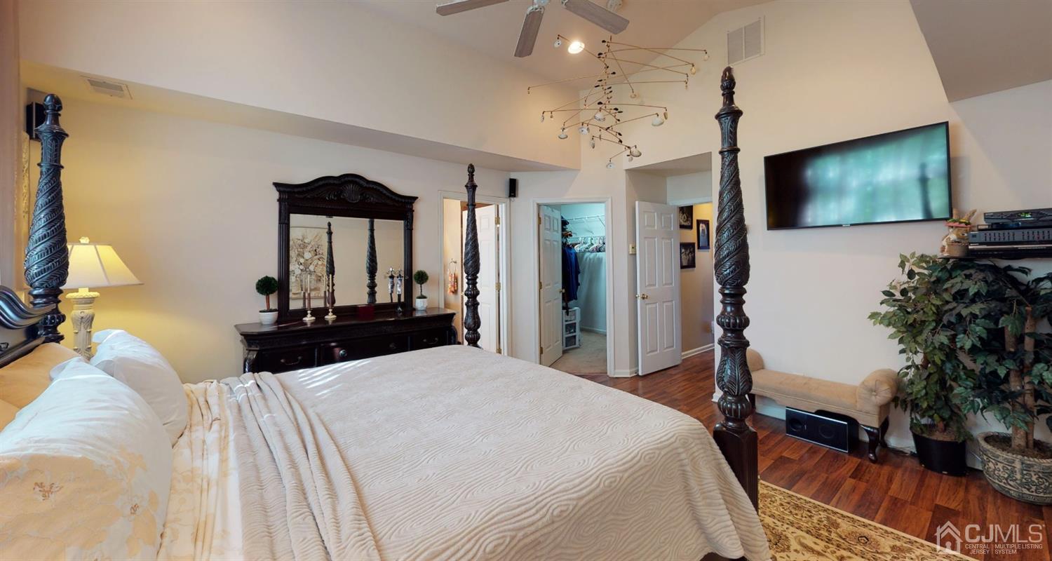 1069 Shadowlawn Drive, Unit 604 Green Brook, NJ 08812 - Photo 22 of 45 a bedroom with a large bed a flat tv screen and a chandelier