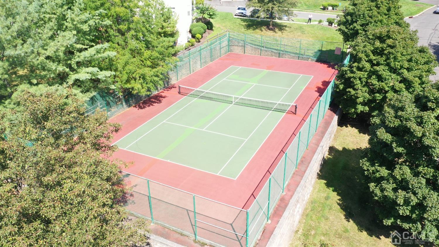 1069 Shadowlawn Drive, Unit 604 Green Brook, NJ 08812 - Photo 44 of 45 an aerial view of a tennis ground with large trees