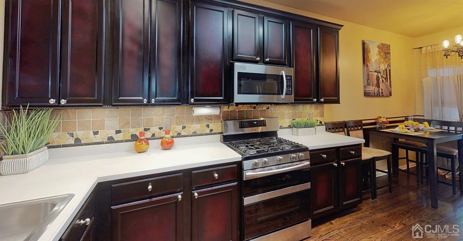 1069 Shadowlawn Drive, Unit 604 Green Brook, NJ 08812 - Photo 7 of 45 a kitchen with stainless steel appliances granite countertop a stove a sink dishwasher and cabinets with wooden floor