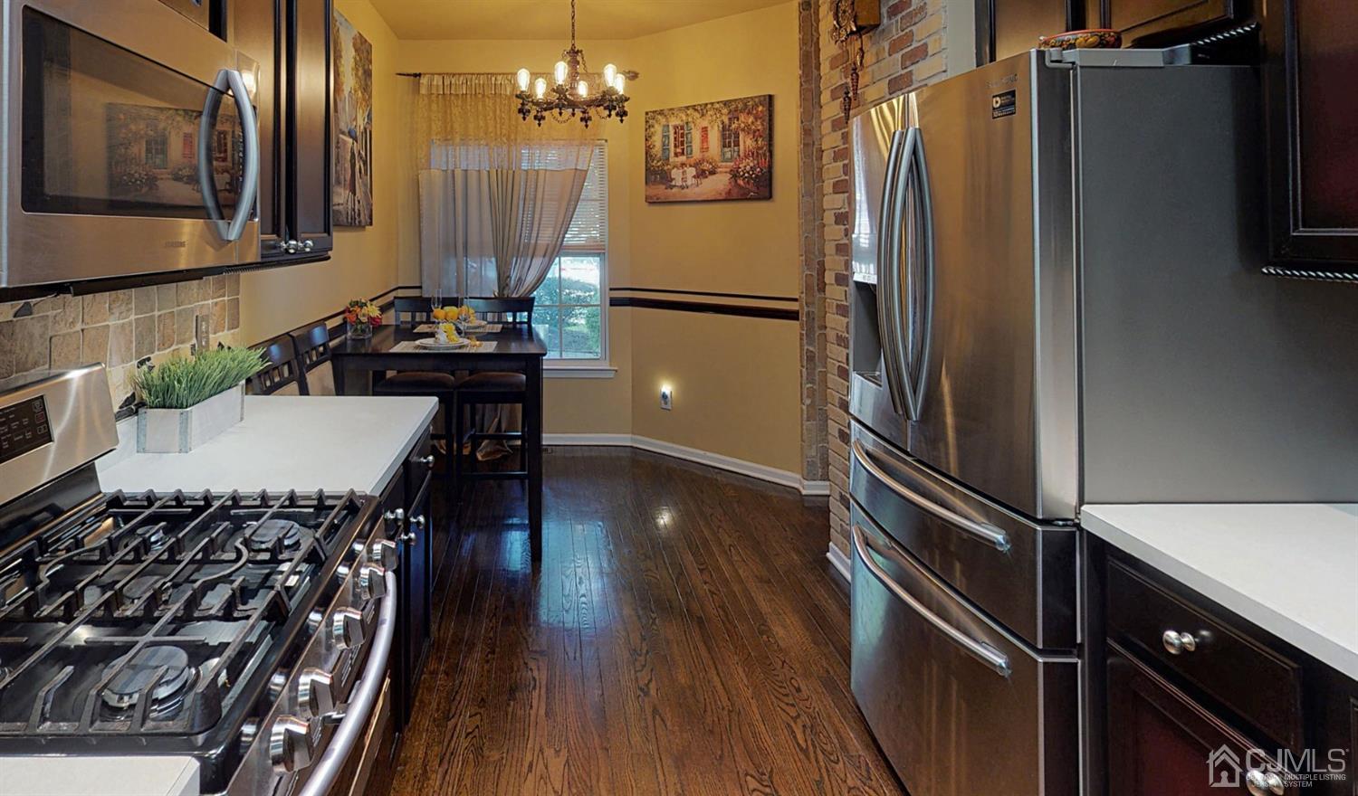 1069 Shadowlawn Drive, Unit 604 Green Brook, NJ 08812 - Photo 8 of 45 a kitchen with stainless steel appliances a refrigerator a stove a sink and a dining table