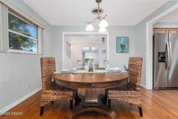 a view of an empty room with window and wooden floor