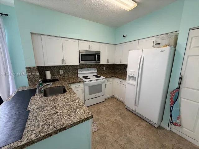 a kitchen with a refrigerator a stove a microwave and cabinets