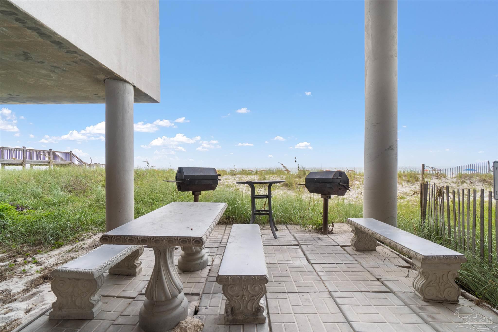 14511 Perdido Key Drive, Unit 508 Perdido Key, FL 32507 - Photo 58 of 59 a view of a patio with a table chairs and a floor to ceiling window