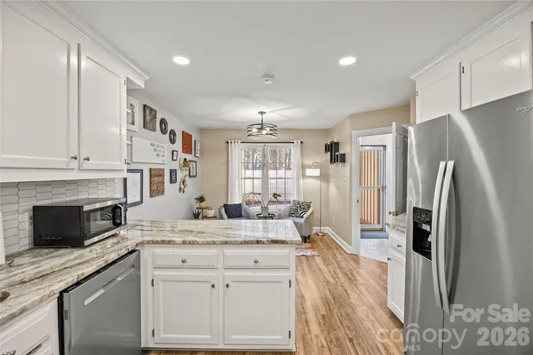 a kitchen with granite countertop a stove sink and cabinets