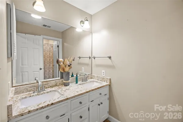 a bathroom with a granite countertop sink and a mirror