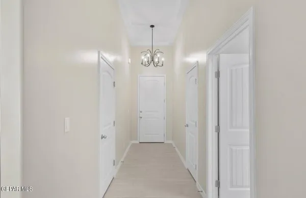 a view of a hallway with chandelier and entryway
