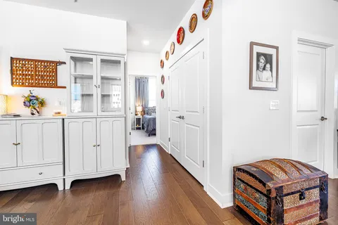 a view of hallway with window and wooden floor