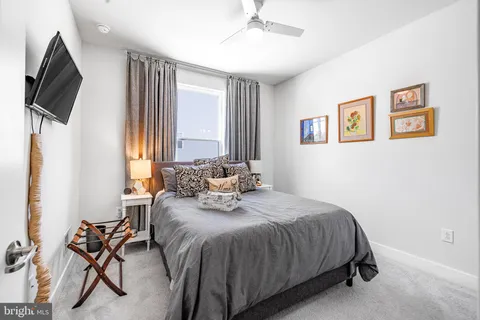 a bedroom with a bed tv and a window