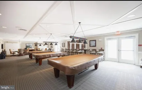 a room with pool table and windows