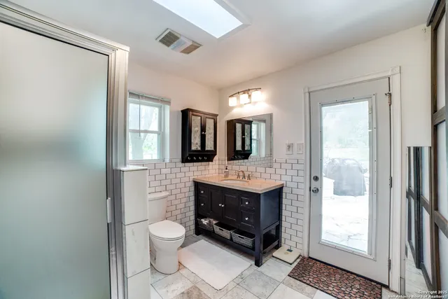 a bathroom with a toilet a sink and mirror