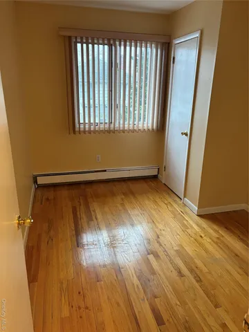a view of a room with wooden floor and a window