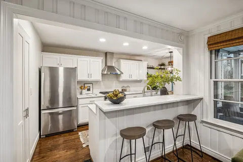 a kitchen with stainless steel appliances a stove a sink a refrigerator and cabinets