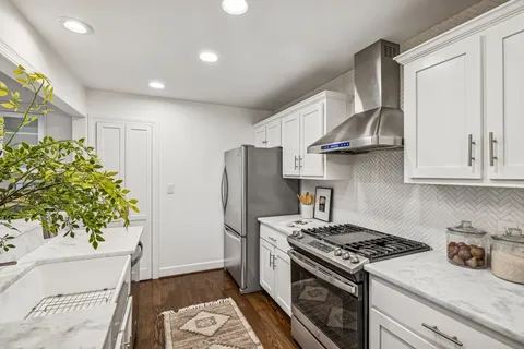 a kitchen with stainless steel appliances a table and chairs in it