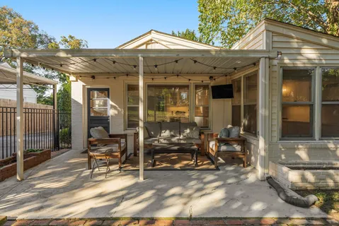 a view of a patio with table and chairs potted plants and large tree