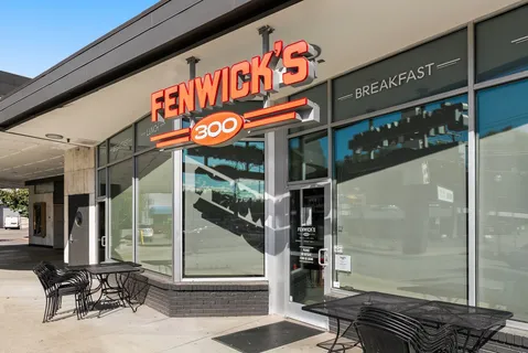 a view of a cafe with a table and chairs under an umbrella