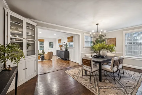 a dining room with furniture potted plants and wooden floor