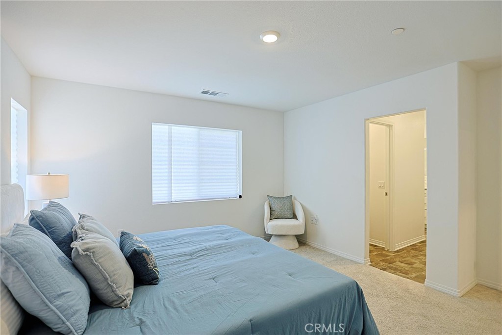 7486 Olive Grv Street Riverside, CA 92507 - Photo 27 of 57 a bedroom with a bed and a window