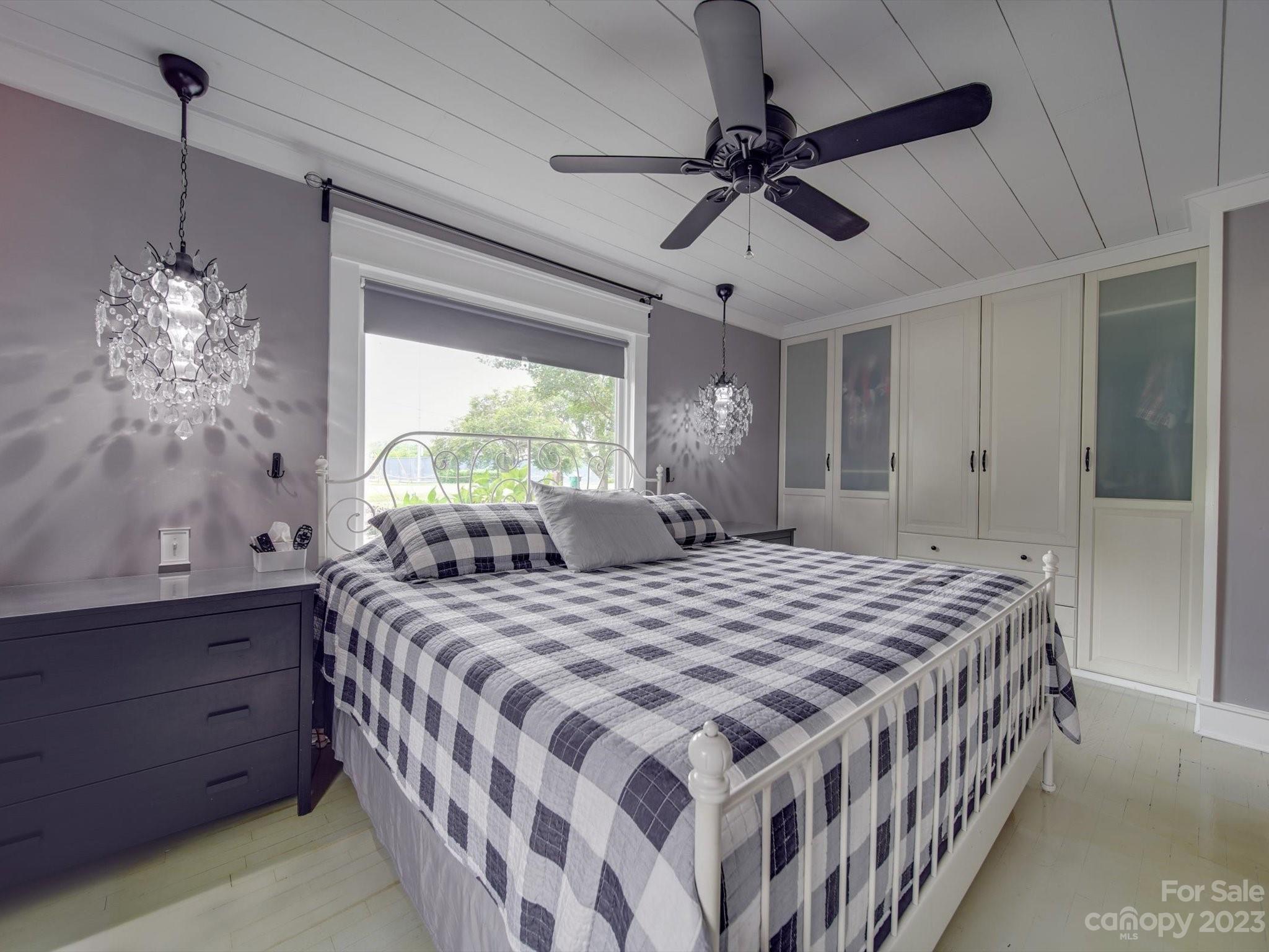 4197 Stallings Road Harrisburg, NC 28075 - Photo 15 of 41 a bedroom with a bed and a chandelier