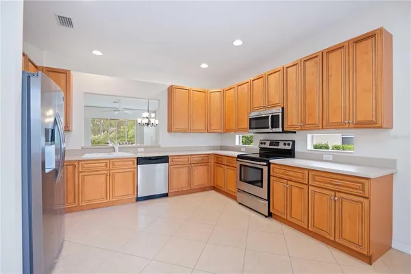 a kitchen with stainless steel appliances granite countertop a refrigerator a stove top oven a sink and dishwasher