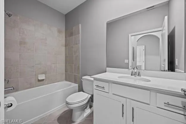 a bathroom with a toilet a sink a mirror a bathtub and vanity