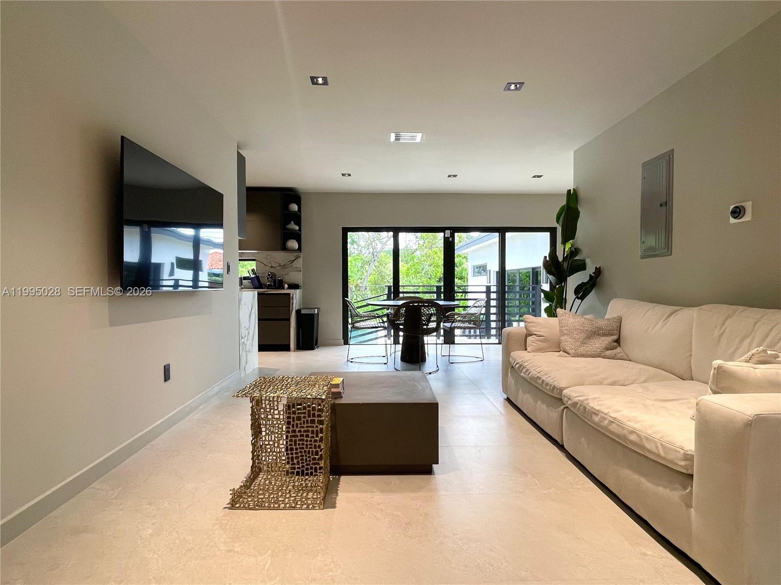 2155 Southwest 25th Terrace Miami, FL 33133 - Photo 6 of 13 a living room with furniture a large window and a flat screen tv