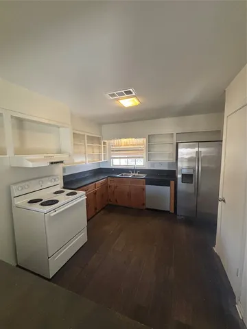 a kitchen with stainless steel appliances granite countertop a stove a sink and a refrigerator