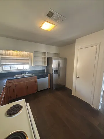 a kitchen with granite countertop a sink and a stove top oven