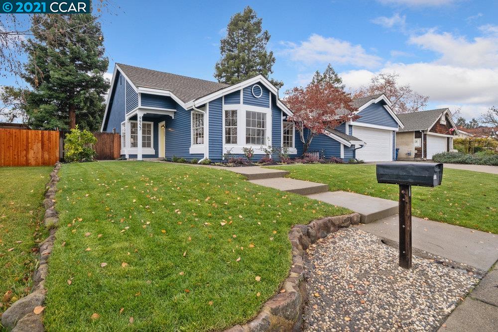 a front view of a house with a yard and trees
