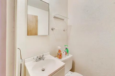 a bathroom with a sink mirror and toilet