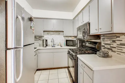a kitchen with a refrigerator sink and cabinets