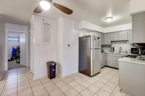 a kitchen with a refrigerator and white cabinets