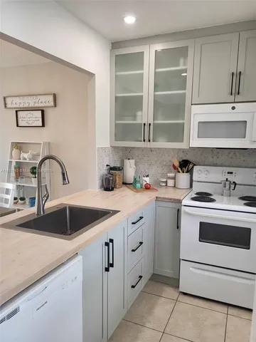 a kitchen with sink a stove and cabinets