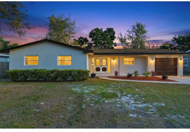 a backyard of a house with table and chairs