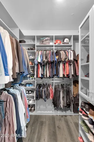 a view of walk in closet with clothes and shoes