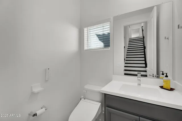 a bathroom with a sink a toilet and mirror