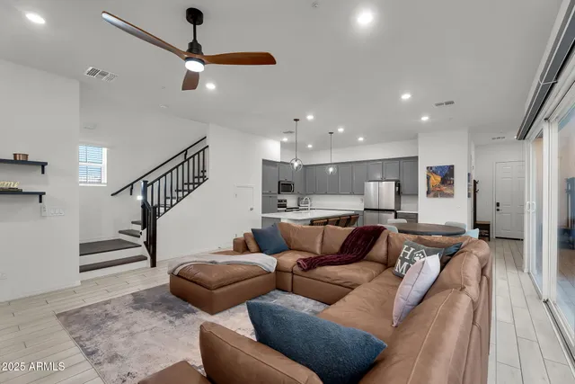 a living room with furniture and a ceiling fan
