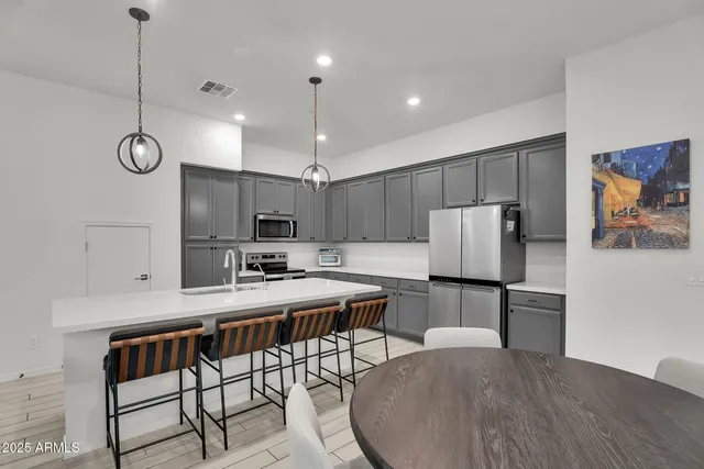 a kitchen with a table chairs stove and refrigerator