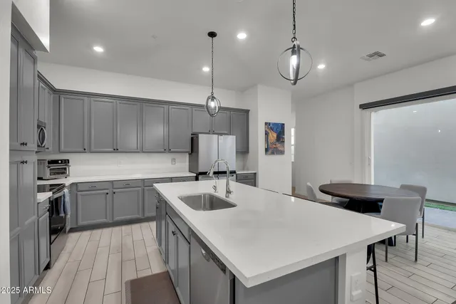 a kitchen with a sink a counter space appliances and cabinets