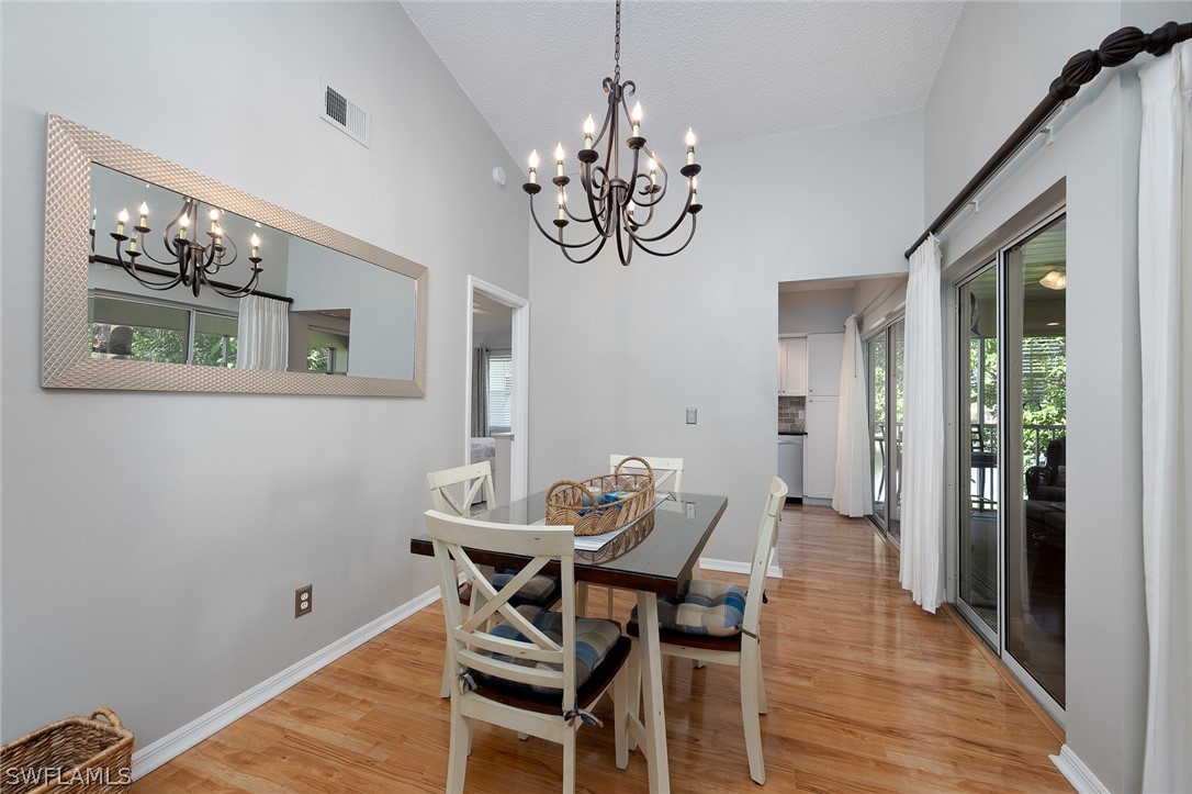 14979 Rivers Edge Court, Unit 223 Fort Myers, FL 33908 - Photo 7 of 21 a view of a dining room with furniture wooden floor and chandelier
