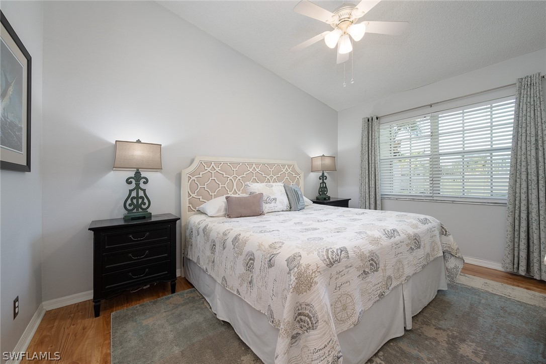 14979 Rivers Edge Court, Unit 223 Fort Myers, FL 33908 - Photo 8 of 21 a bedroom with a bed and a chandelier