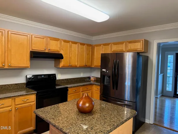 a kitchen with stainless steel appliances granite countertop a refrigerator a stove and a sink