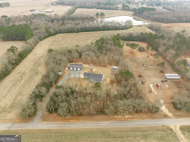 a view of a dry yard with wooden fence
